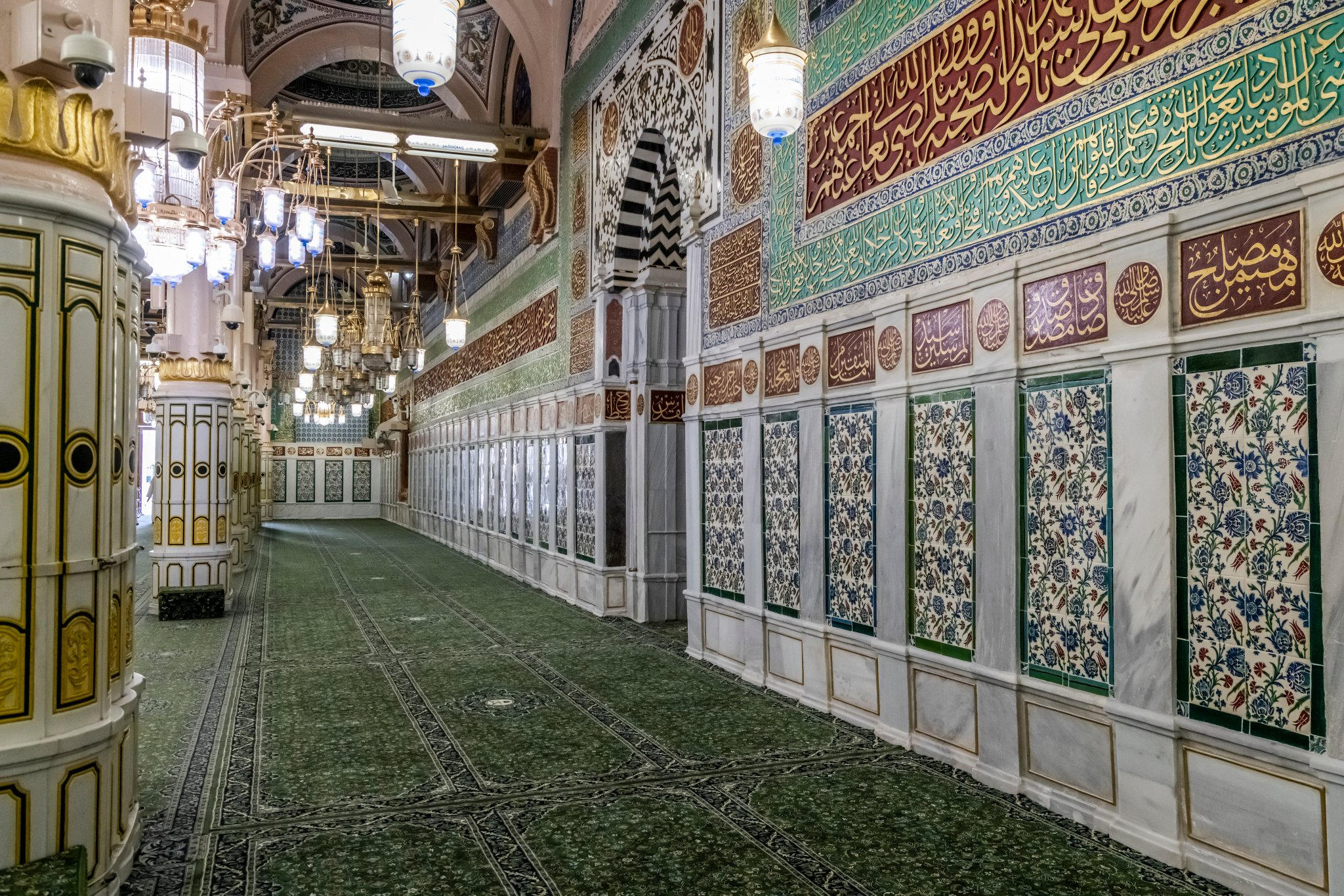 الرواق الداخلي للمسجد النبوي بسجاد أخضر وزخارف إسلامية